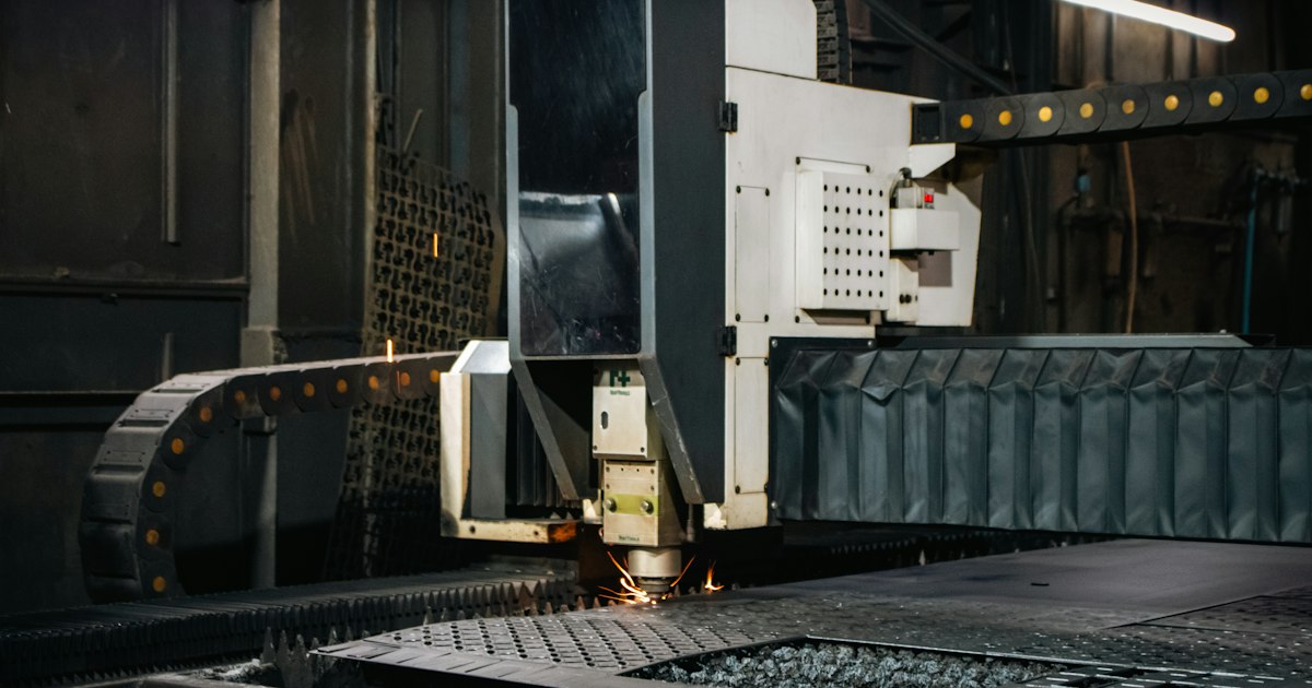 Fiber laser cutting head cutting a steel sheet in a fabrication shop